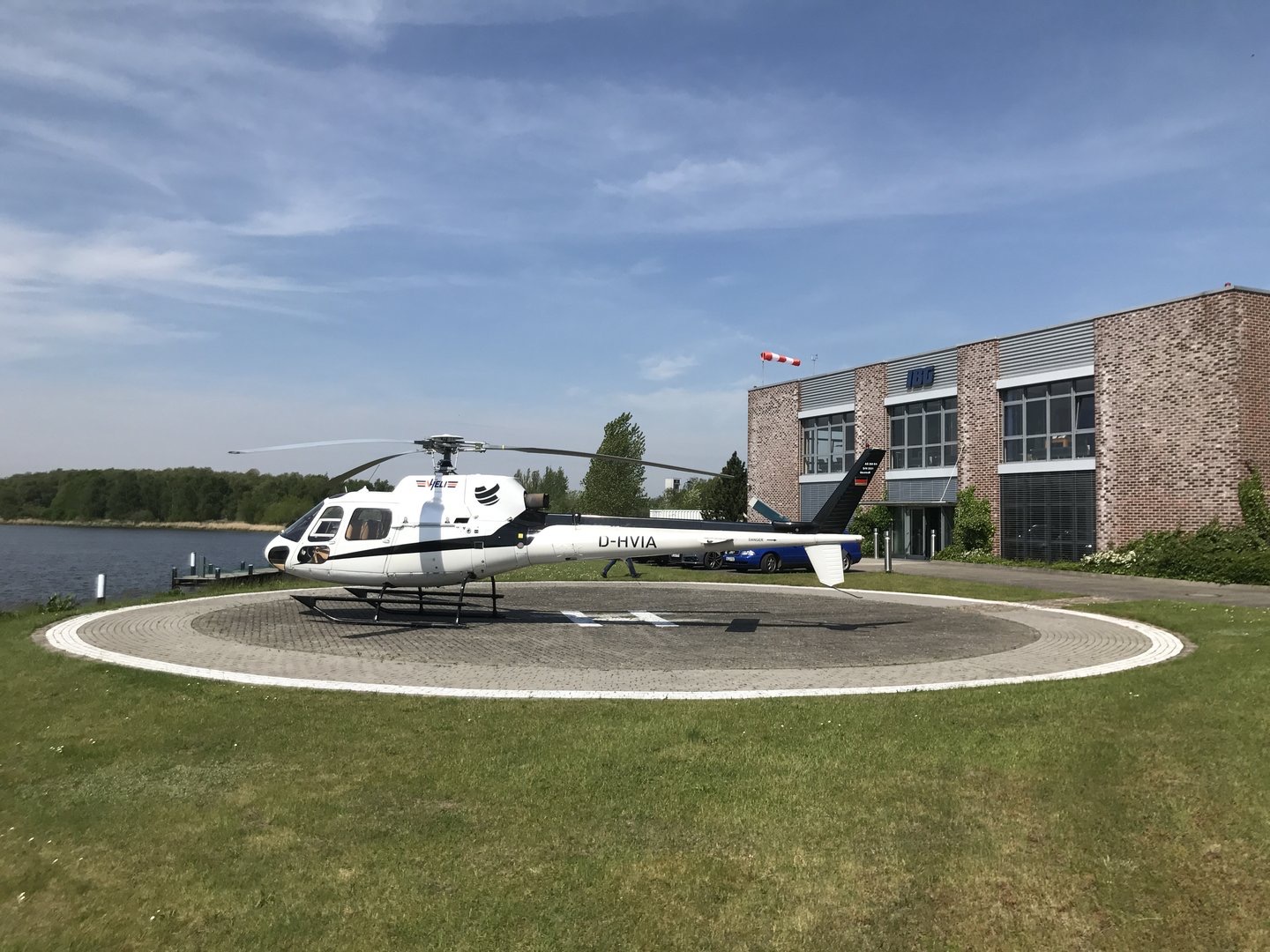 AS350 auf einem runden Hubschrauberlandeplatz vor einem Backsteingebäude