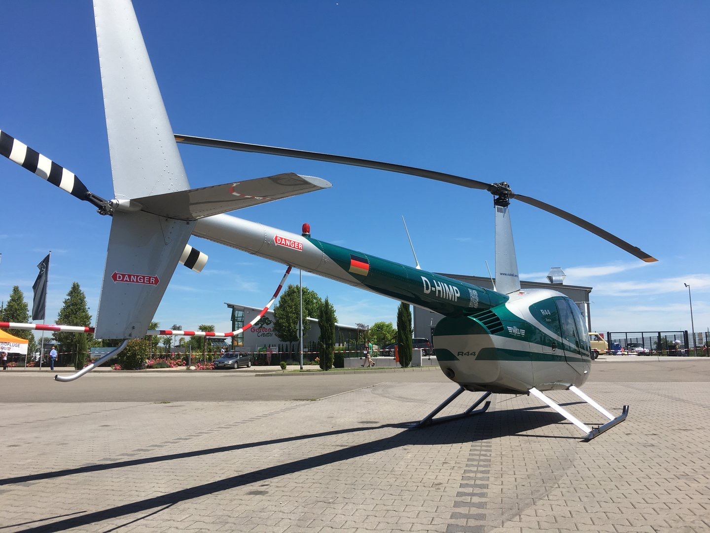 Robinson R44 mit grün-weißer Lackierung auf einem gepflasterten Platz